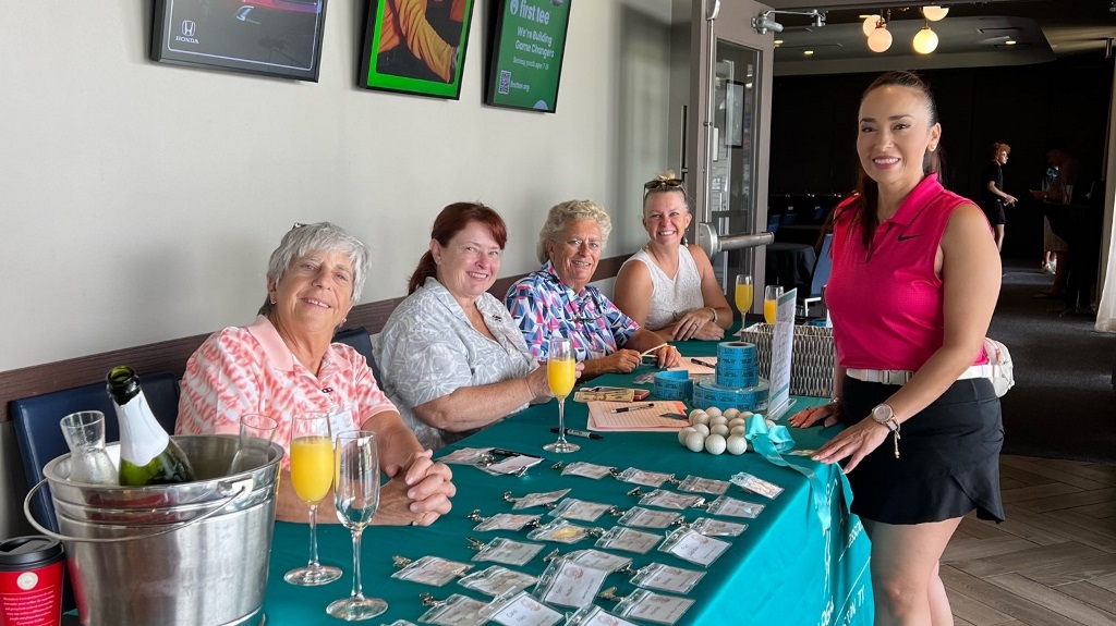 A group of female golfers hosting the registration table and mimosas before a golf tournament in Houston Texas