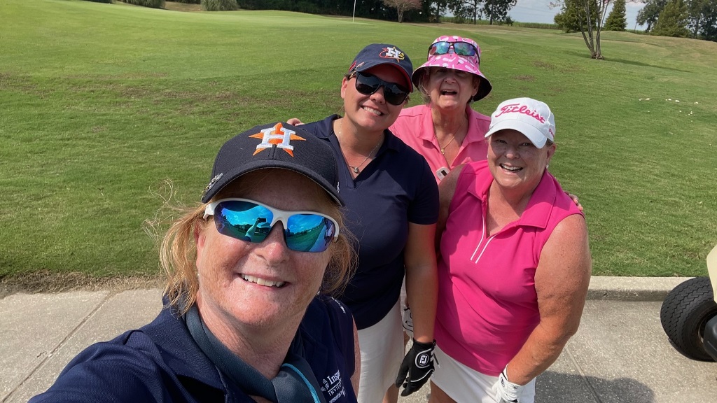 Four female golfers posing for a team selfie during a round of golf in Houston Texas