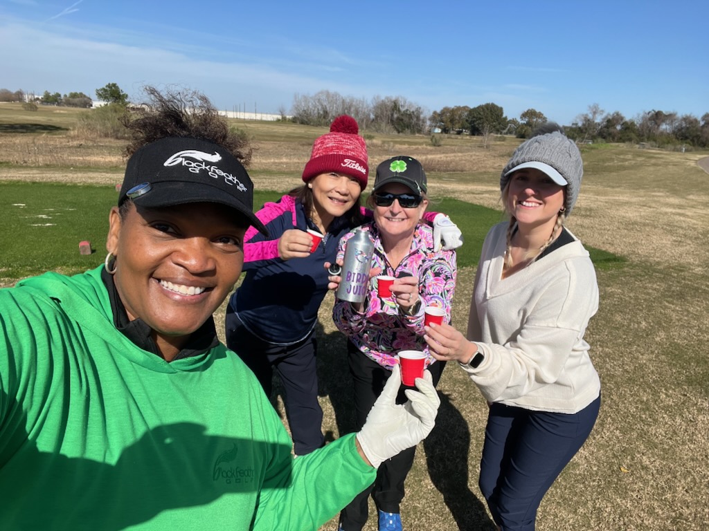 Four female golfers celebrating a birdie during a chilly round of golf in Houston Texas
