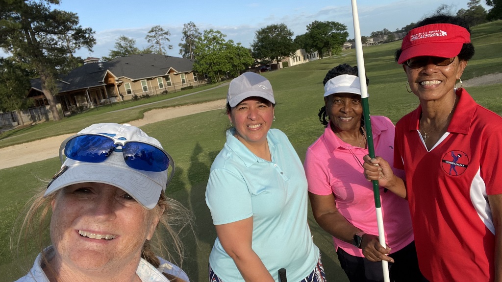 Four female golfers on the 18th hole celebrating a round of golf in Houston Texas