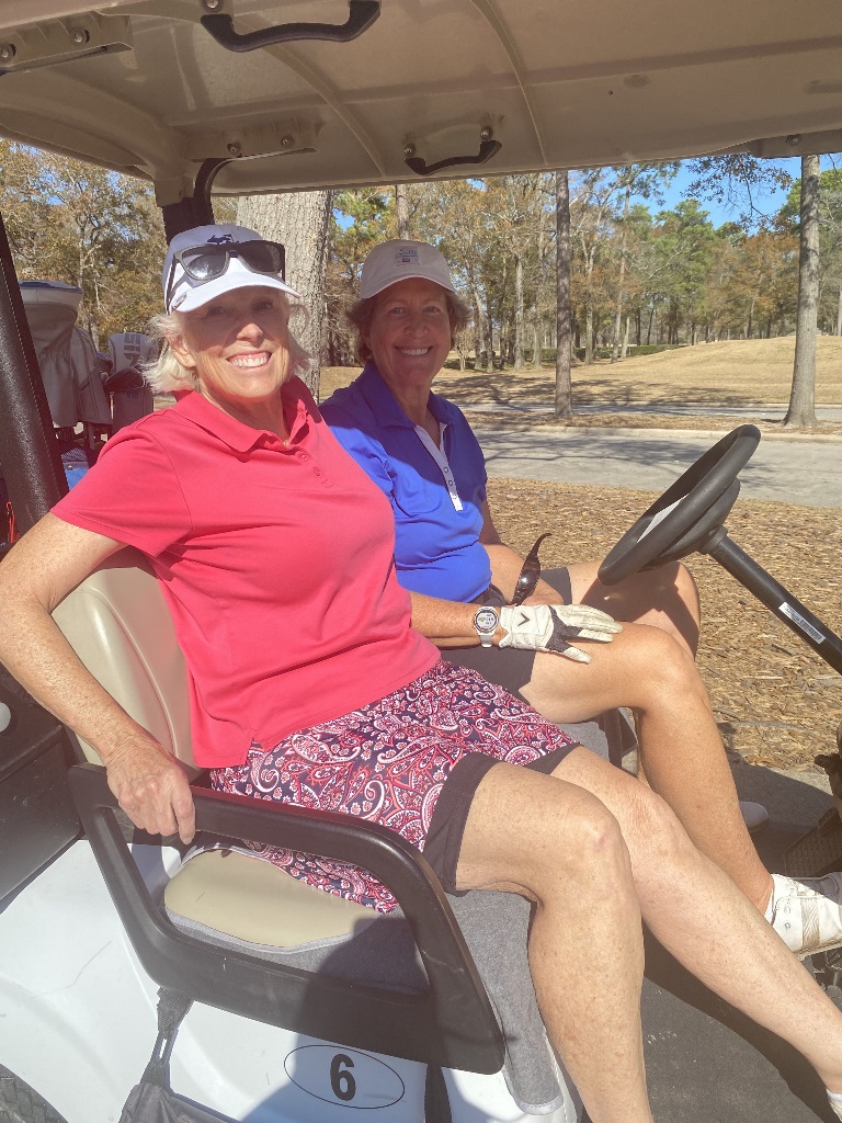Two female golfers in a golf cart getting ready to play a round of golf in Houston Texas