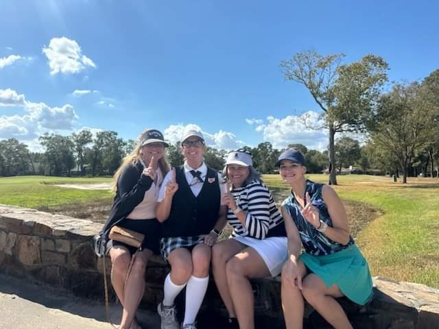 Four female golfers giving peace signs while playing a round of golf in Houston Texas
