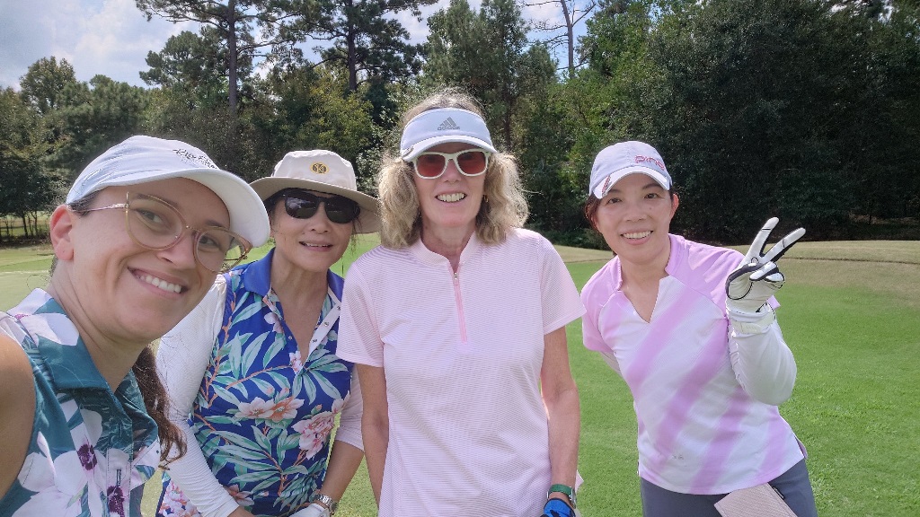 Four female golfers taking a selfie on the golf course in Houston Texas