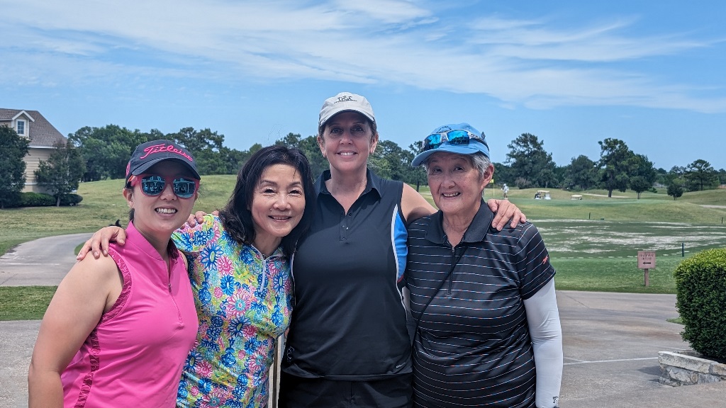 Four female golfers posing for a picture at the clubhouse during a round of golf in Houston Texas