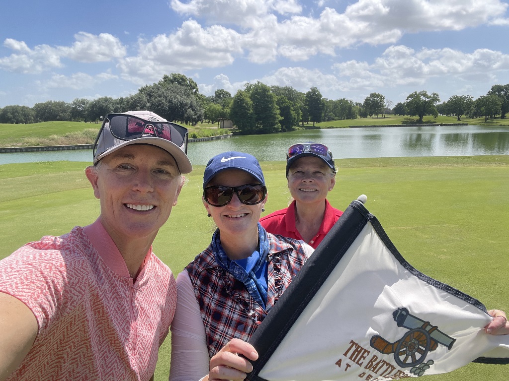 Three female golfers at Battleground golf course in Houston Texas on a hole near a lake