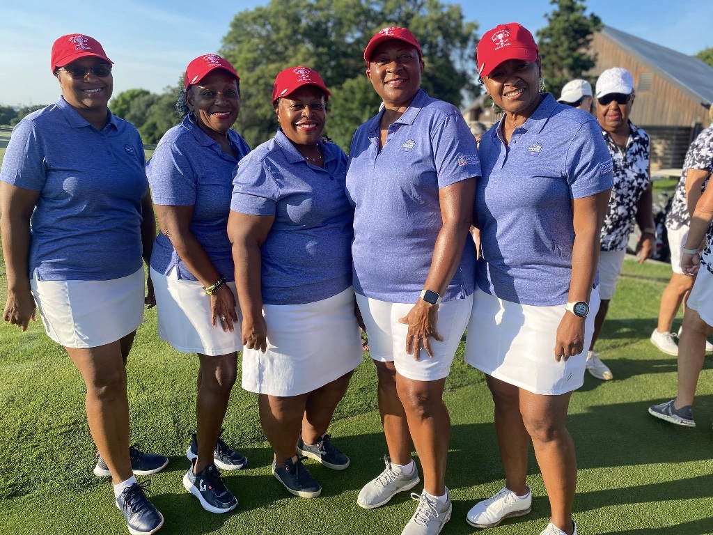 Five female golfers in their team uniforms at a golf tournament representing the Houston Texas team