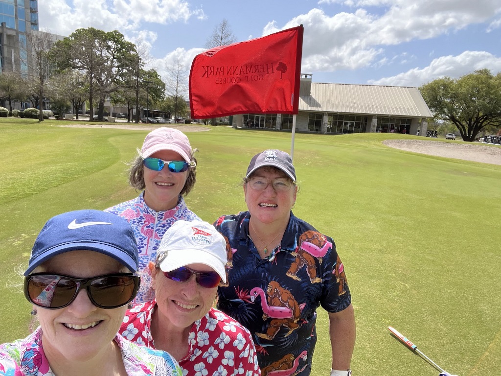Four female golfers taking a selfie on the last hole at a golf course in Houston Texas