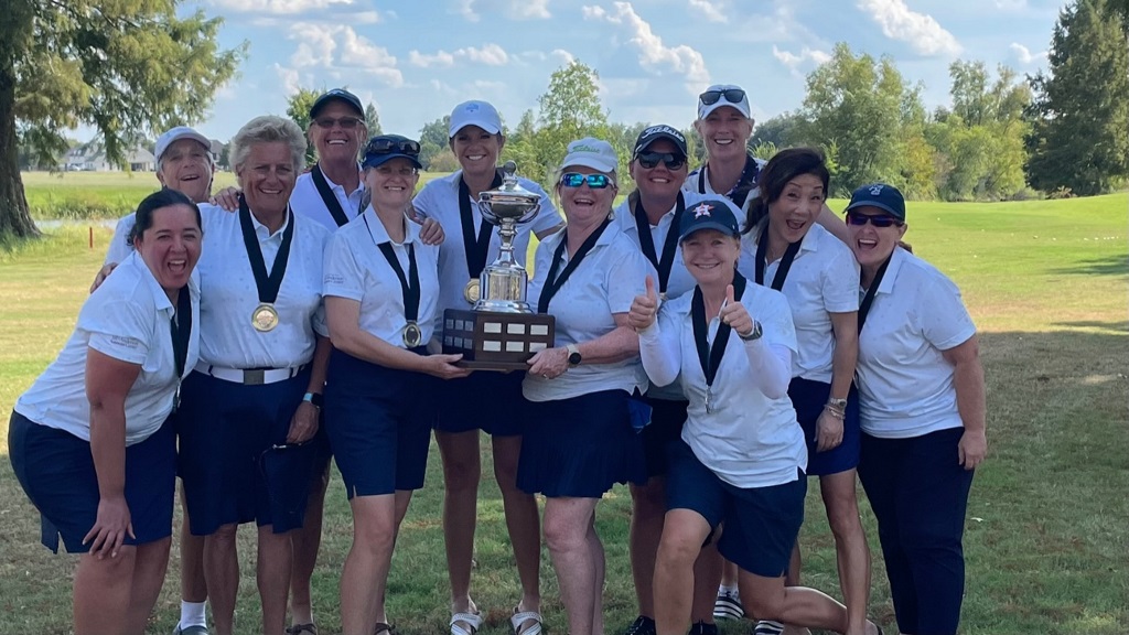 A group of female golfers celebrating a tournament win as a team with their trophy and medals in Houston Texas