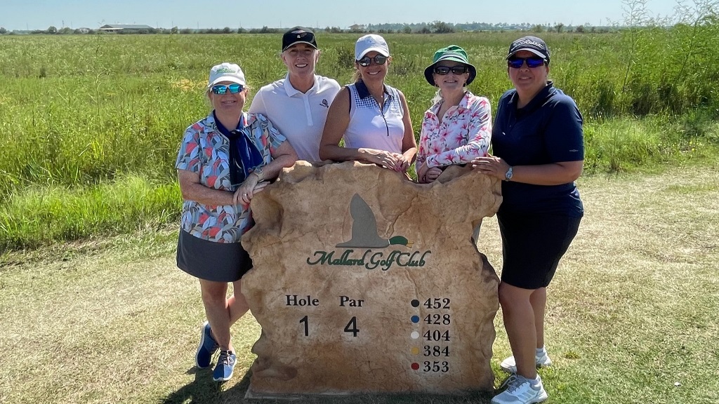Five female golfers posing at the first hole tee box before a round of golf in Houston Texas