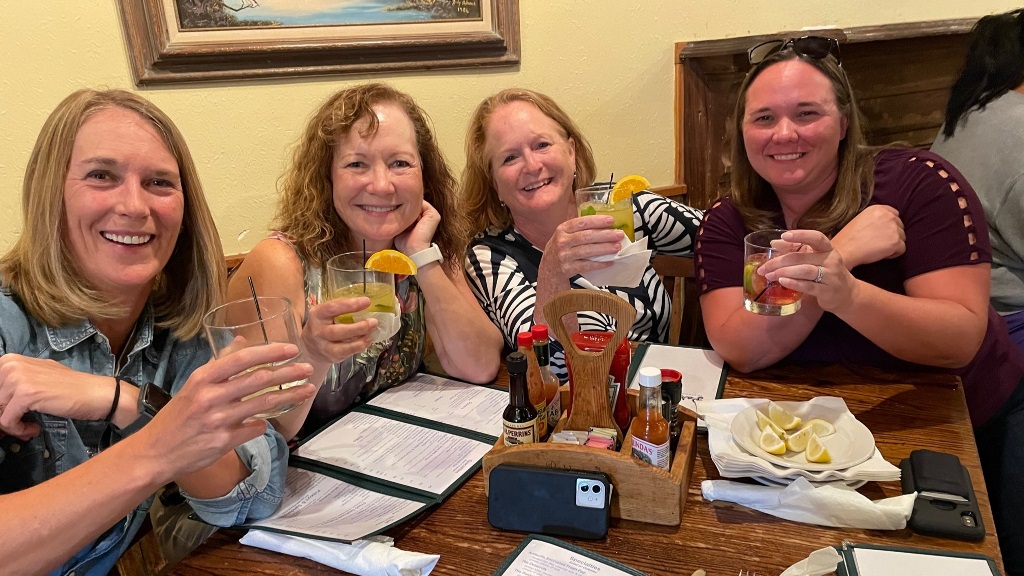 A group of female golfers posing for a photo during a happy hour social event in Houston Texas