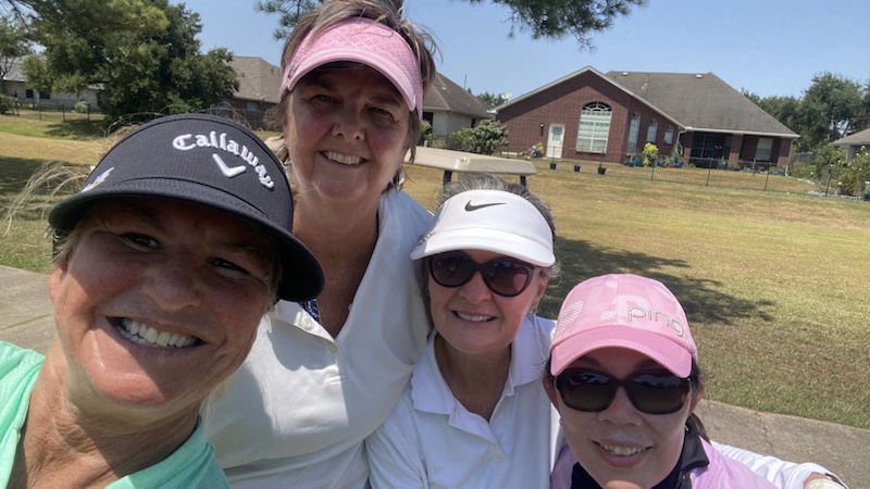 Four female golfers posing for a group selfie during a round of golf in Houston Texas