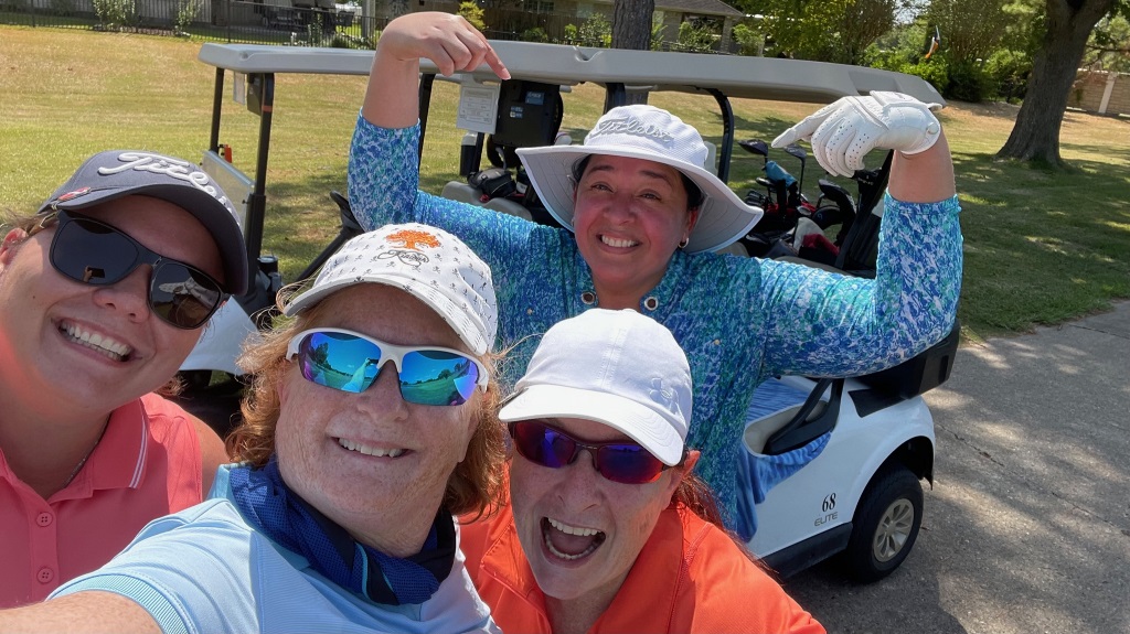 Four female golfers taking a group selfie during a round of golf in Houston Texas