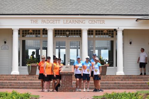 Albuquerque women golfers pose in orange and balloon-themed uniforms outside the Padgett Learning Center during a national event