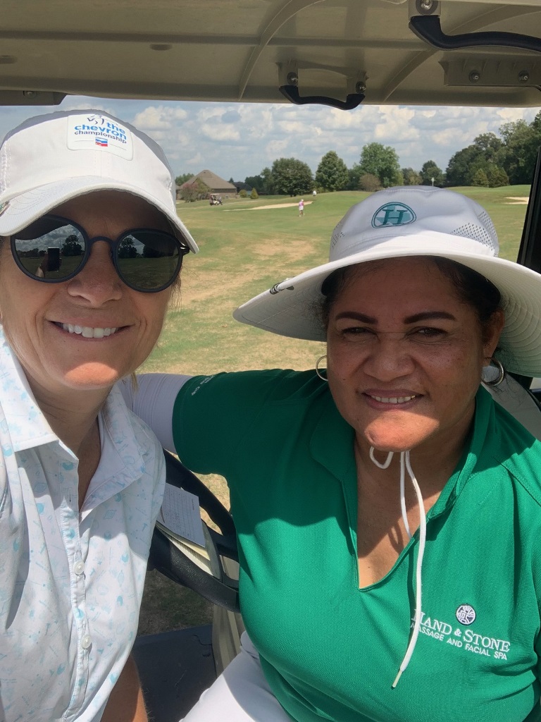 Two female golfers taking a selfie in their golf cart during a match play round of golf in Houston Texas